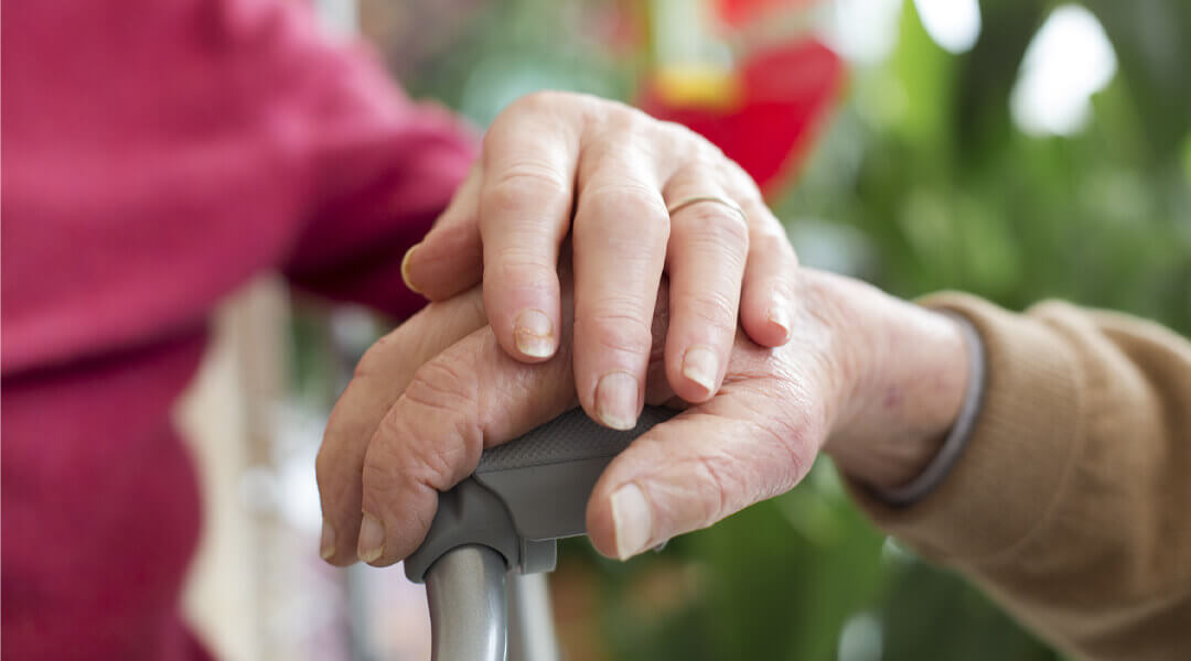 Begleitende Person die eine Patienten Hand zur Stärkung hält